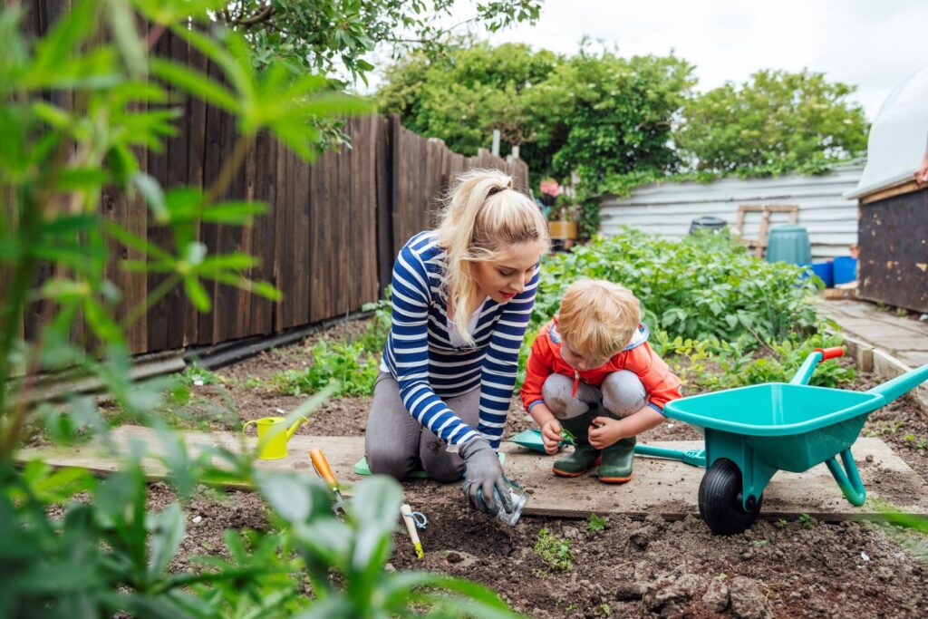 Mum and child in a community garden digging