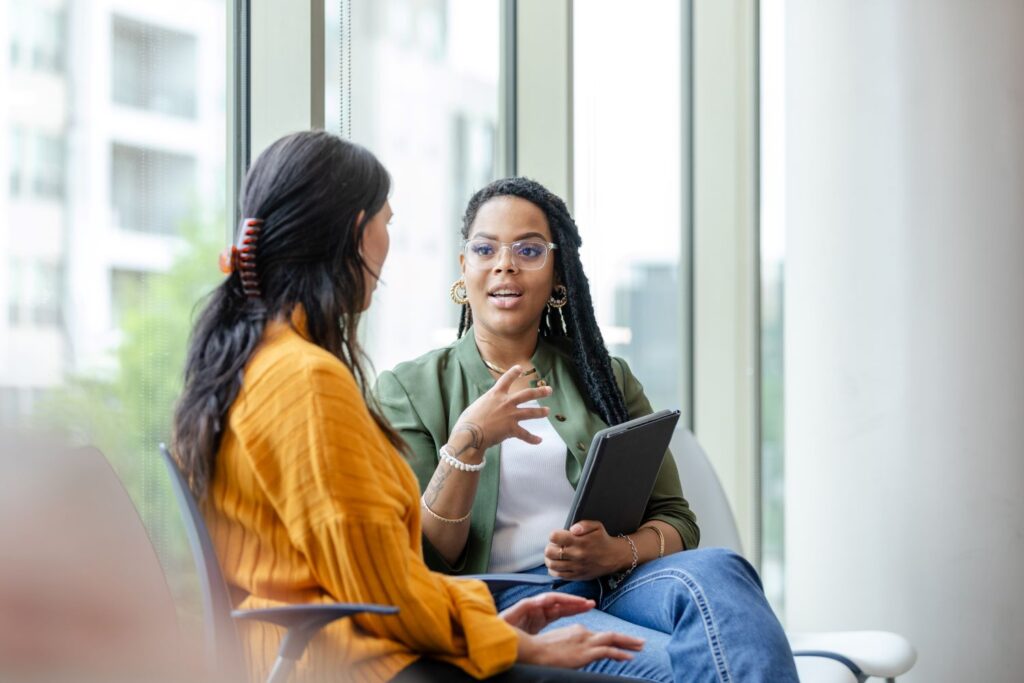 Female therapist sits with female client
