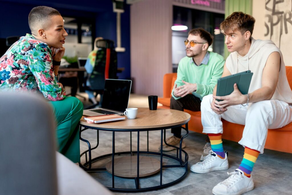 3 people chatting on sofas at a LGBTQ+ community group