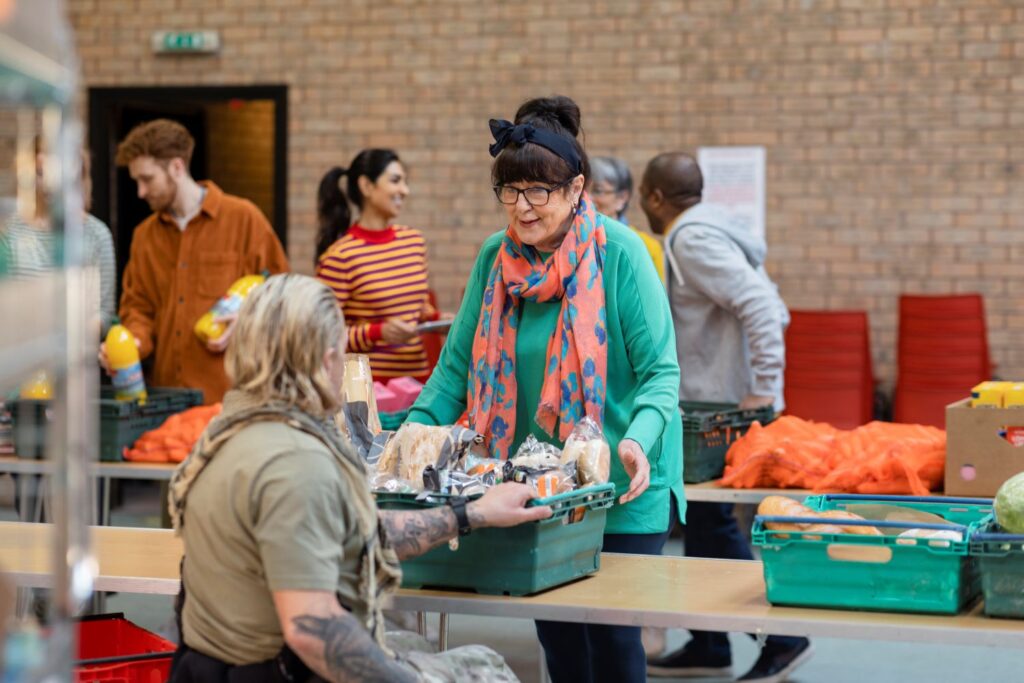 A volunteer hands out a crate of food